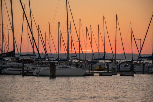 Free Beautiful sunset with sailboats moored at Balaton Lake harbor in Hungary. Stock Photo