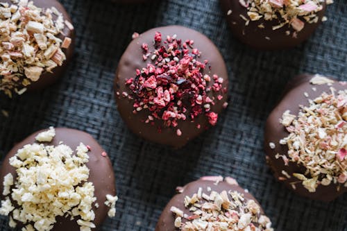 Chocolate covered donuts with sprinkles and nuts