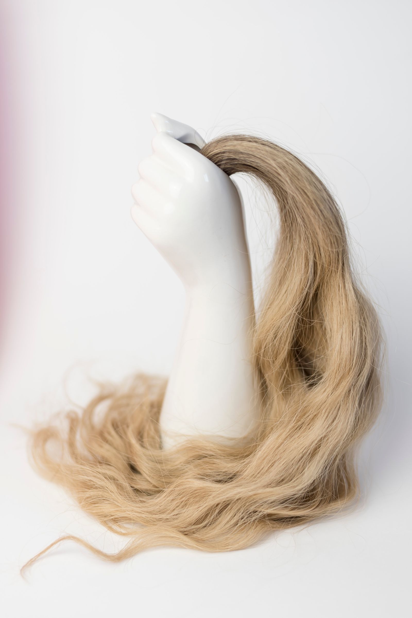A blonde hair topper piece displayed on a mannequin head