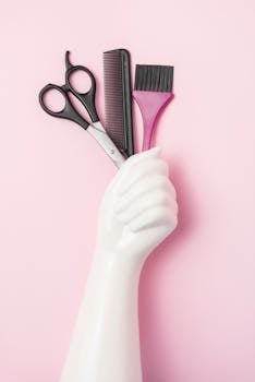 Aesthetic arrangement of hairdressing tools on a pink background for salon style inspiration.