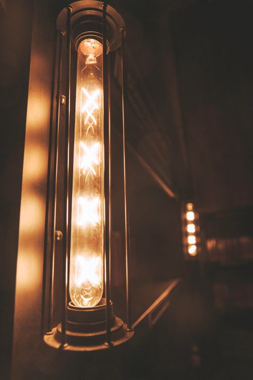 Free Close-up of a vintage Edison bulb encased in an industrial-style cage with warm lighting ambiance. Stock Photo