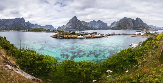 Breathtaking panoramic view of Reine village, Lofoten Islands with turquoise waters and stunning mountain backdrop.