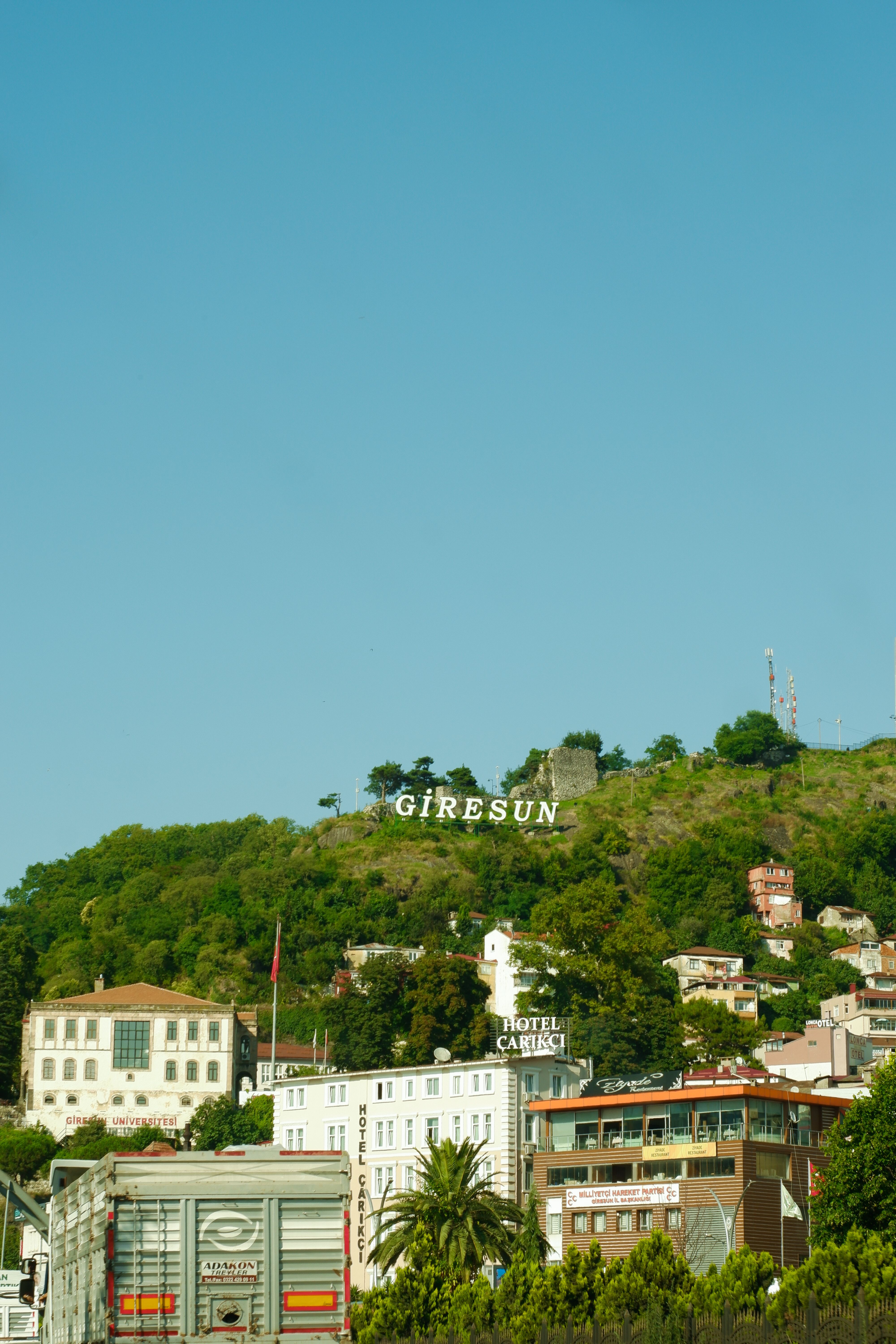 Clear Sky over Hillside Buildings · Free Stock Photo