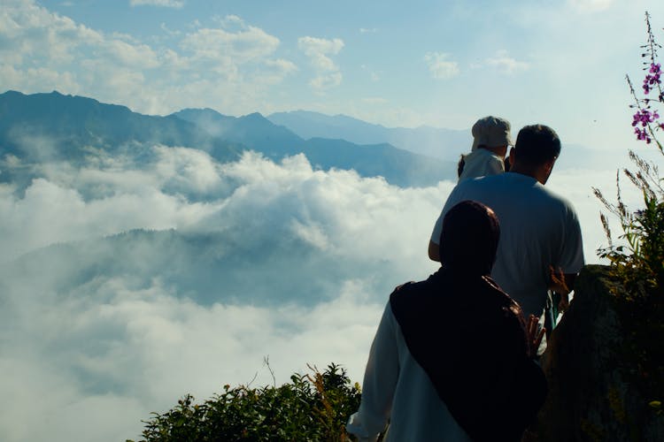 Mother And Father Hiking With Baby In Mountains