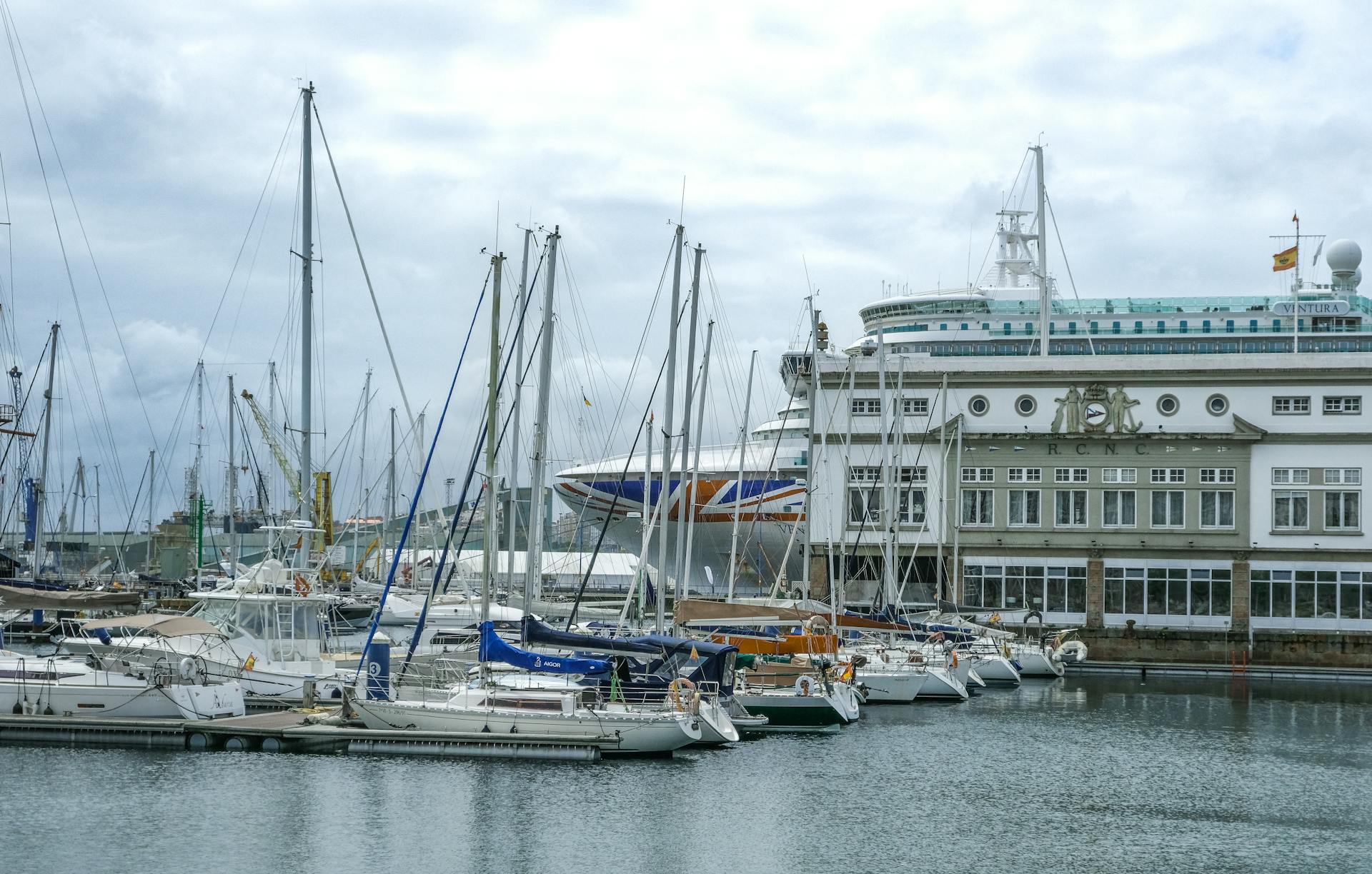 Scenic view of sailboats and cruise ship docked at the port in Corunha, Spain.
