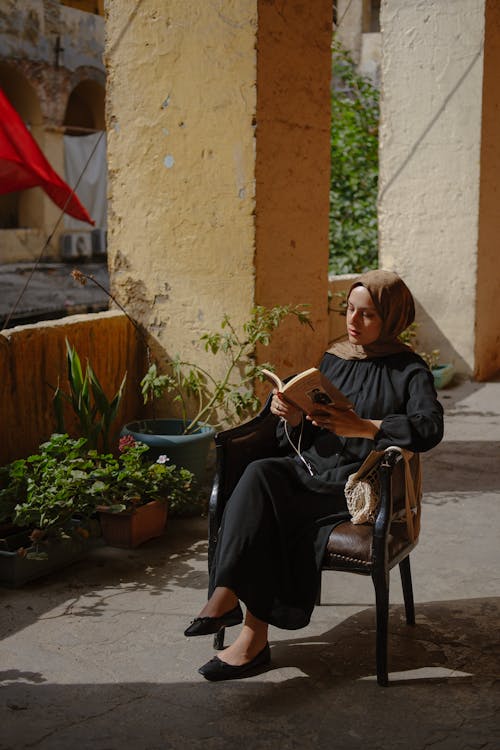 A woman reading a book in a courtyard