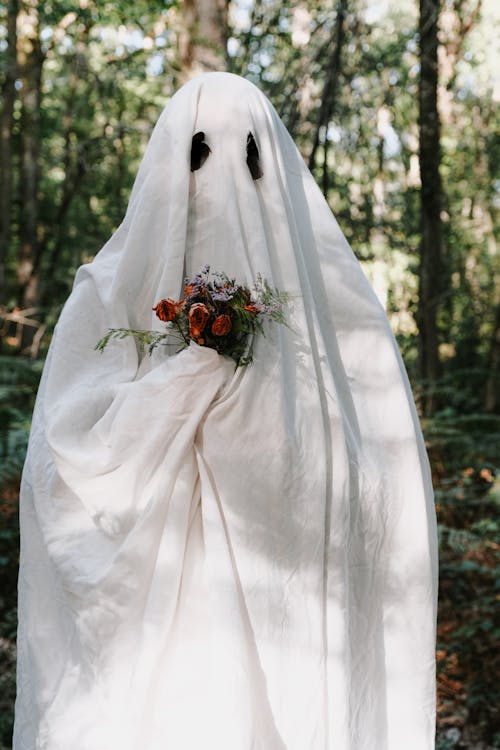 A ghost in a white dress holding a bouquet of flowers