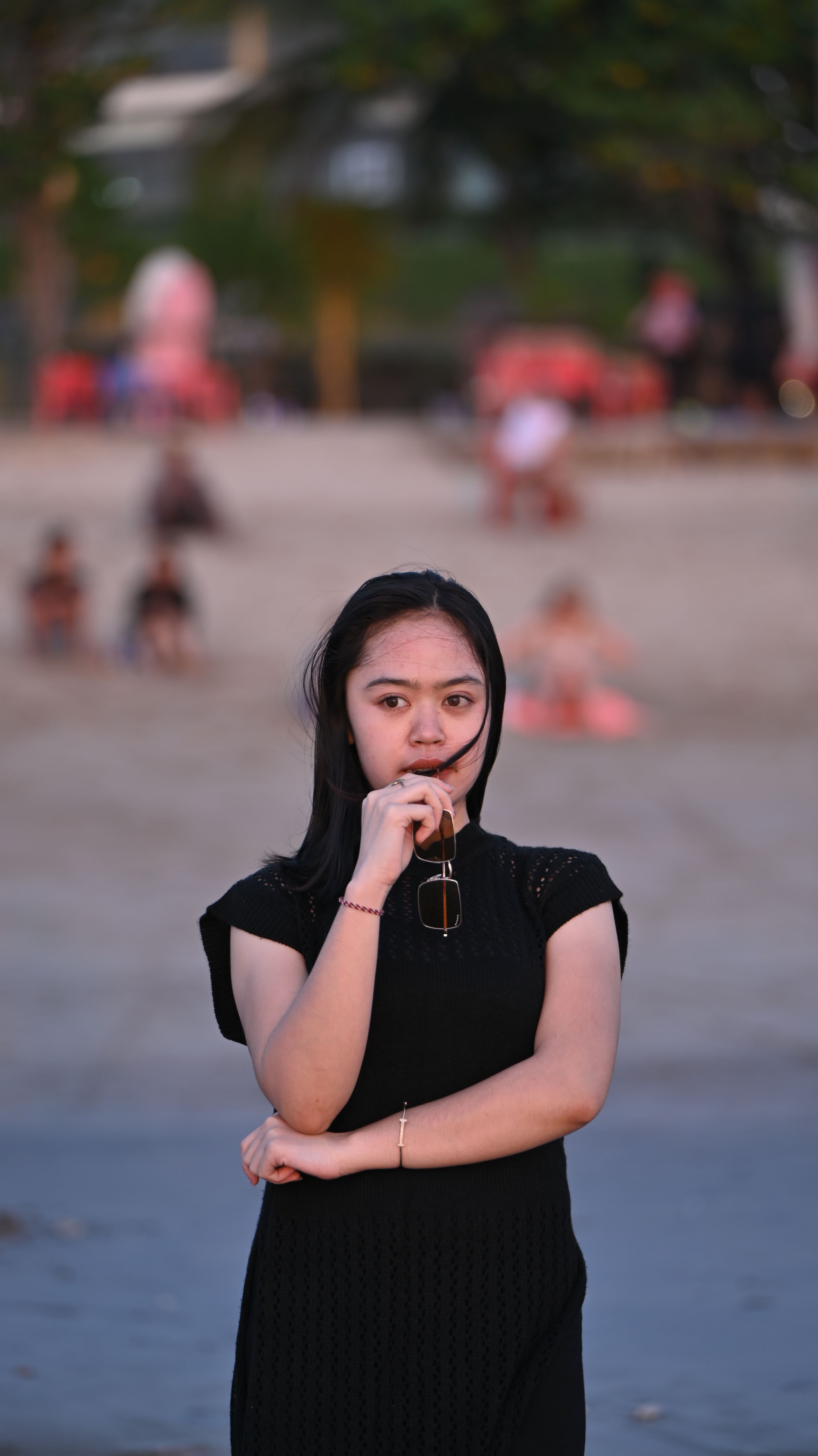Woman in Black Dress Holds Shades