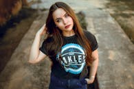 一位留着深色长发的年轻女子穿着休闲装在户外自信地摆出姿势