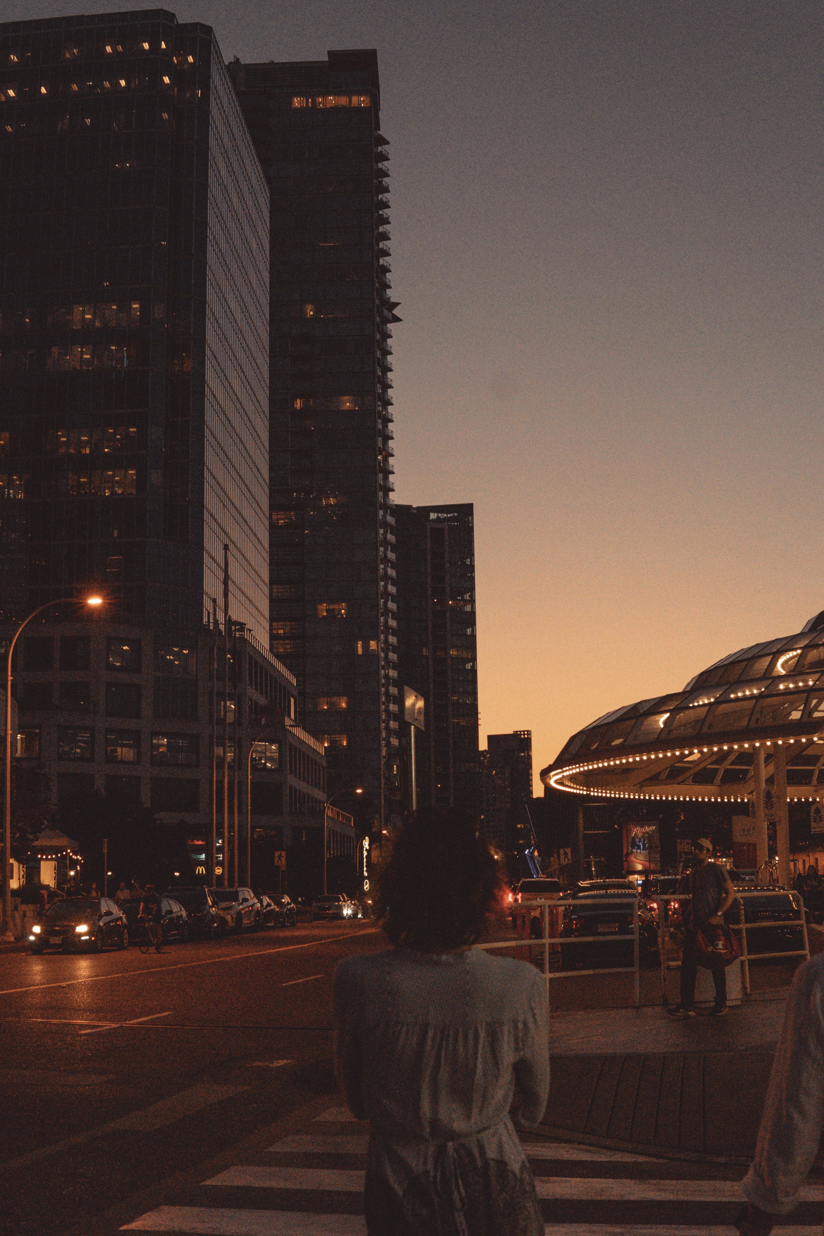 A woman walking down a street at sunset · Free Stock Photo