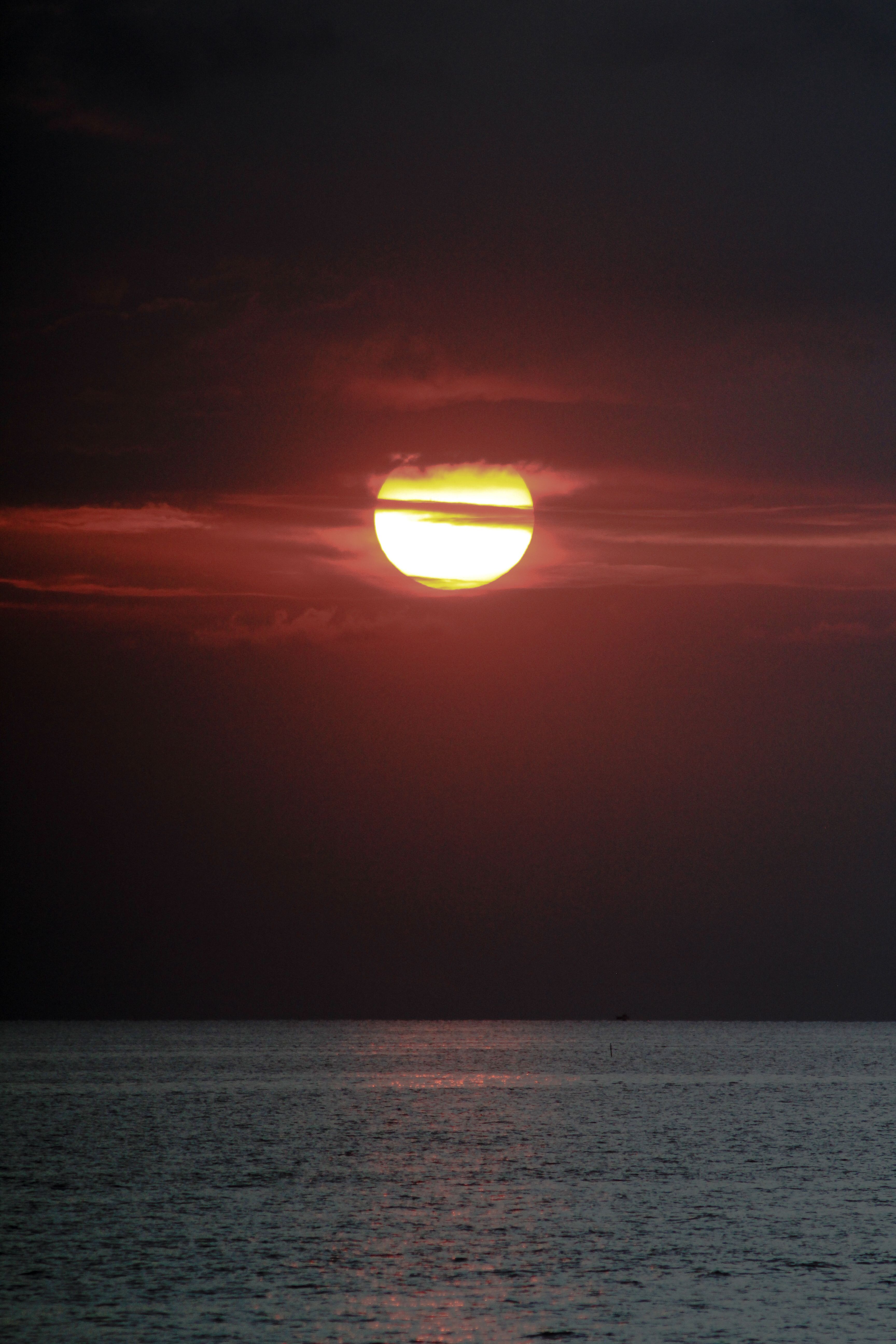 A breathtaking sunset over the sea at Balatan, Bicol, Philippines, highlighting the golden sun and tranquil waters.