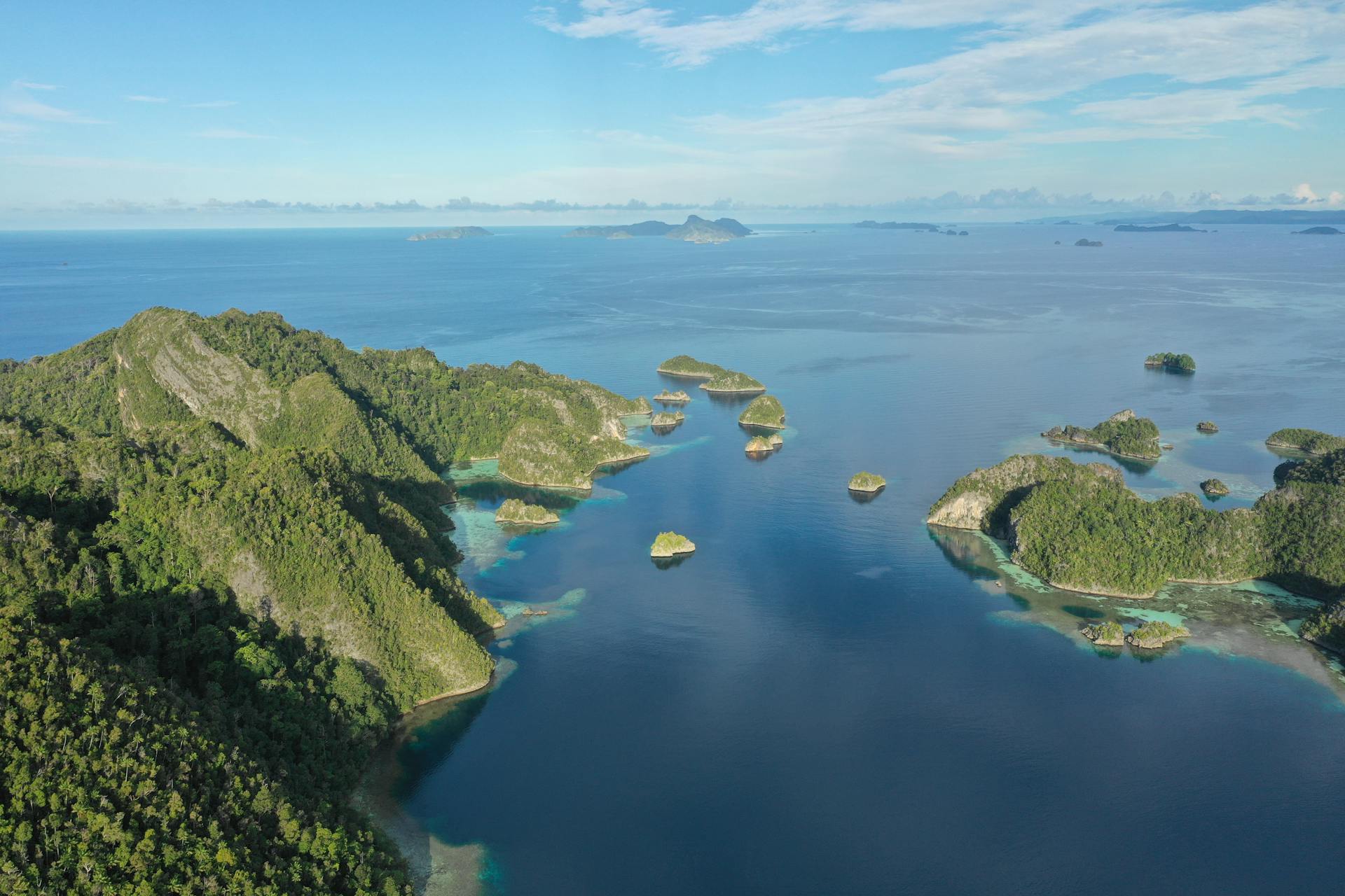 Explore the stunning aerial vista of Raja Ampat's lush islands and azure waters in Indonesia.