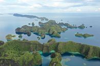 A breathtaking aerial shot of the lush, tropical islands of Raja Ampat, Indonesia.