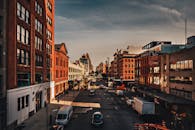 阳光明媚的日子里，繁华的城市街道两旁，历史悠久的建筑和车辆排列有序