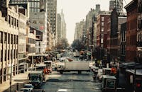 纽约市一条繁忙的街道上，车辆和标志性的城市建筑挤满了街道