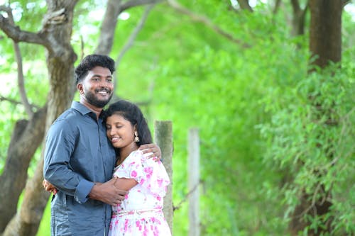 Free A Couple Standing in a Park and Hugging  Stock Photo