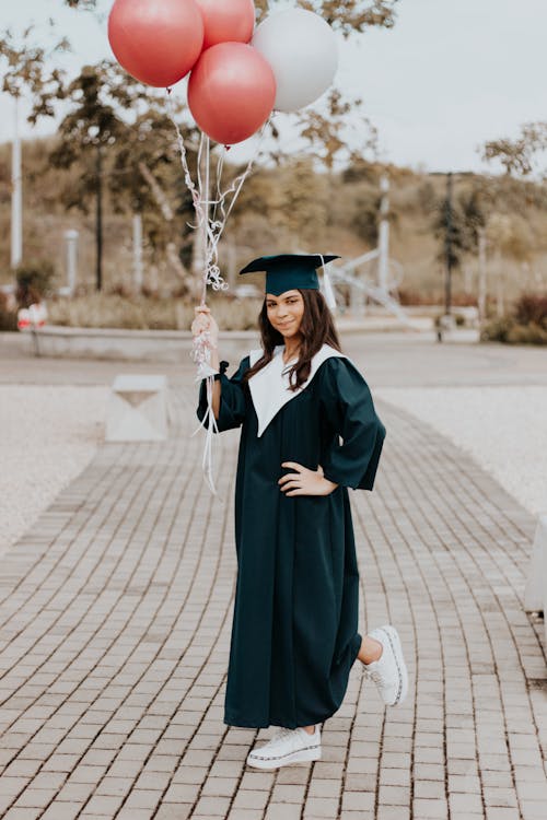 Woman in a Graduation Gown Holding Balloons 