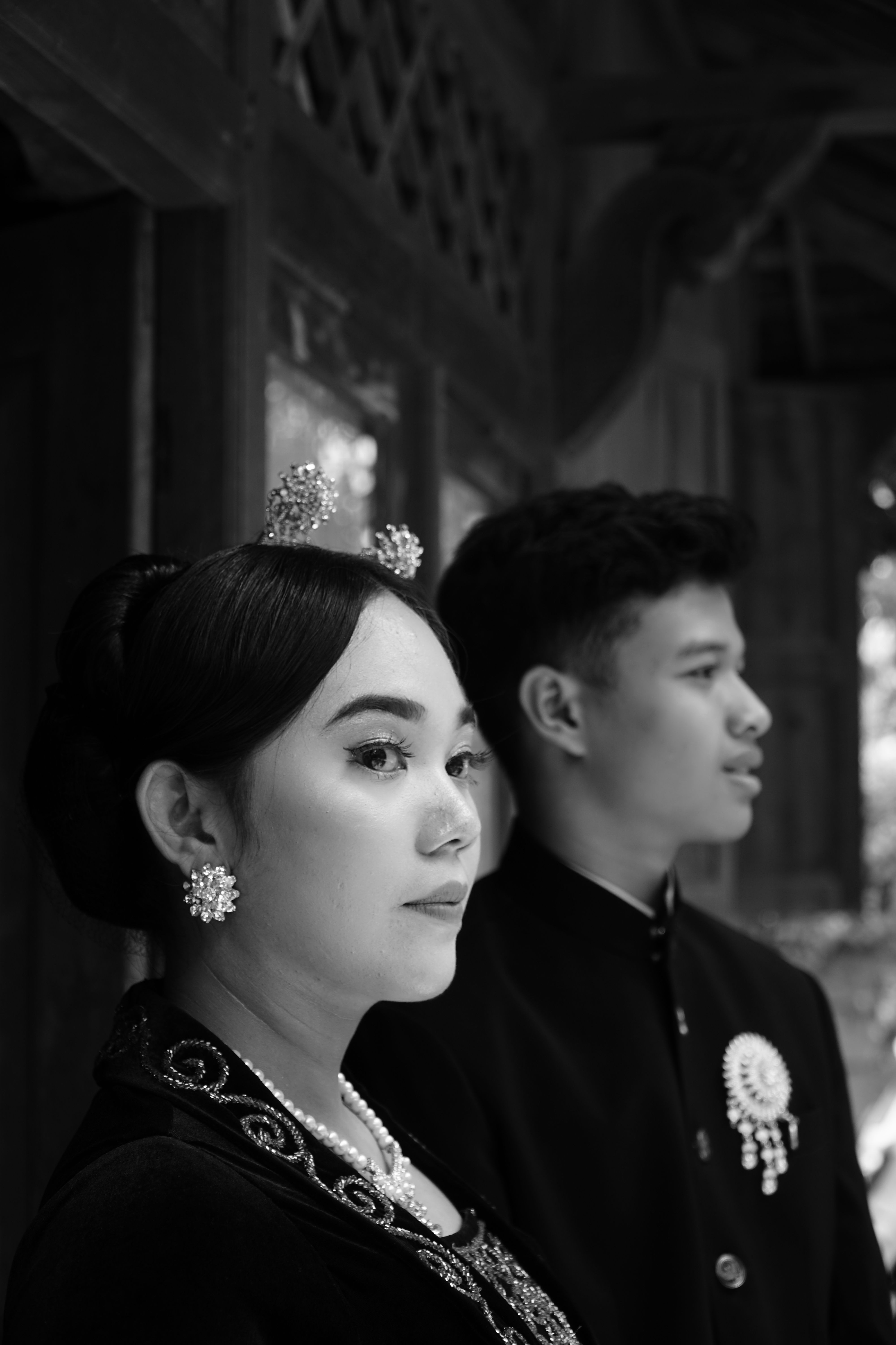 Black and white portrait of a couple in elegant traditional clothing, captured indoors.