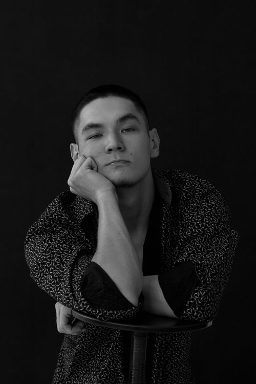 Free Artistic black and white portrait of a man in a patterned shirt, posing thoughtfully. Stock Photo