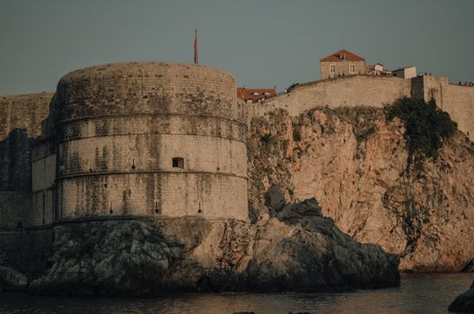 Ancient fortress perched on rocky cliff in Dubrovnik, Croatia. Captivating sunset view.