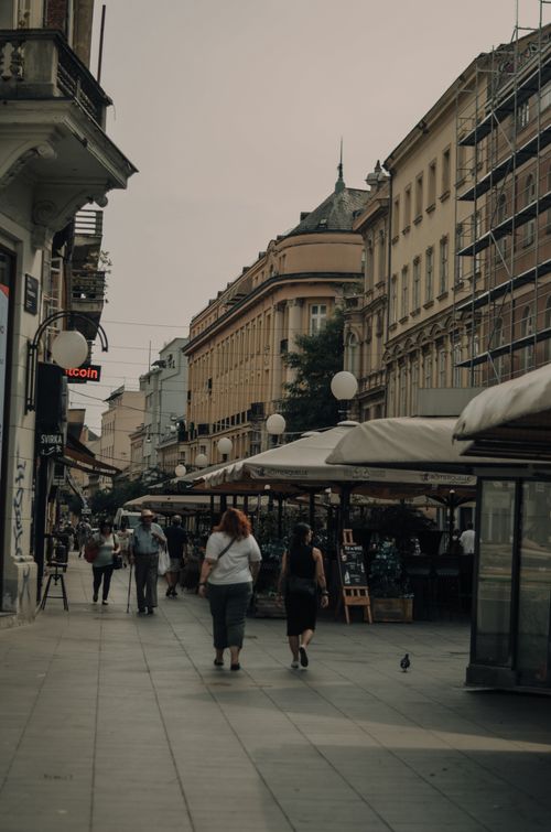 Free A bustling European street lined with historic buildings and lively outdoor cafes. Stock Photo