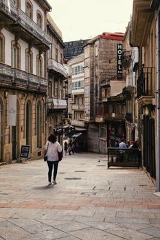 Explore a quaint street in Vigo's old town, showcasing local architecture and vibrant city life.