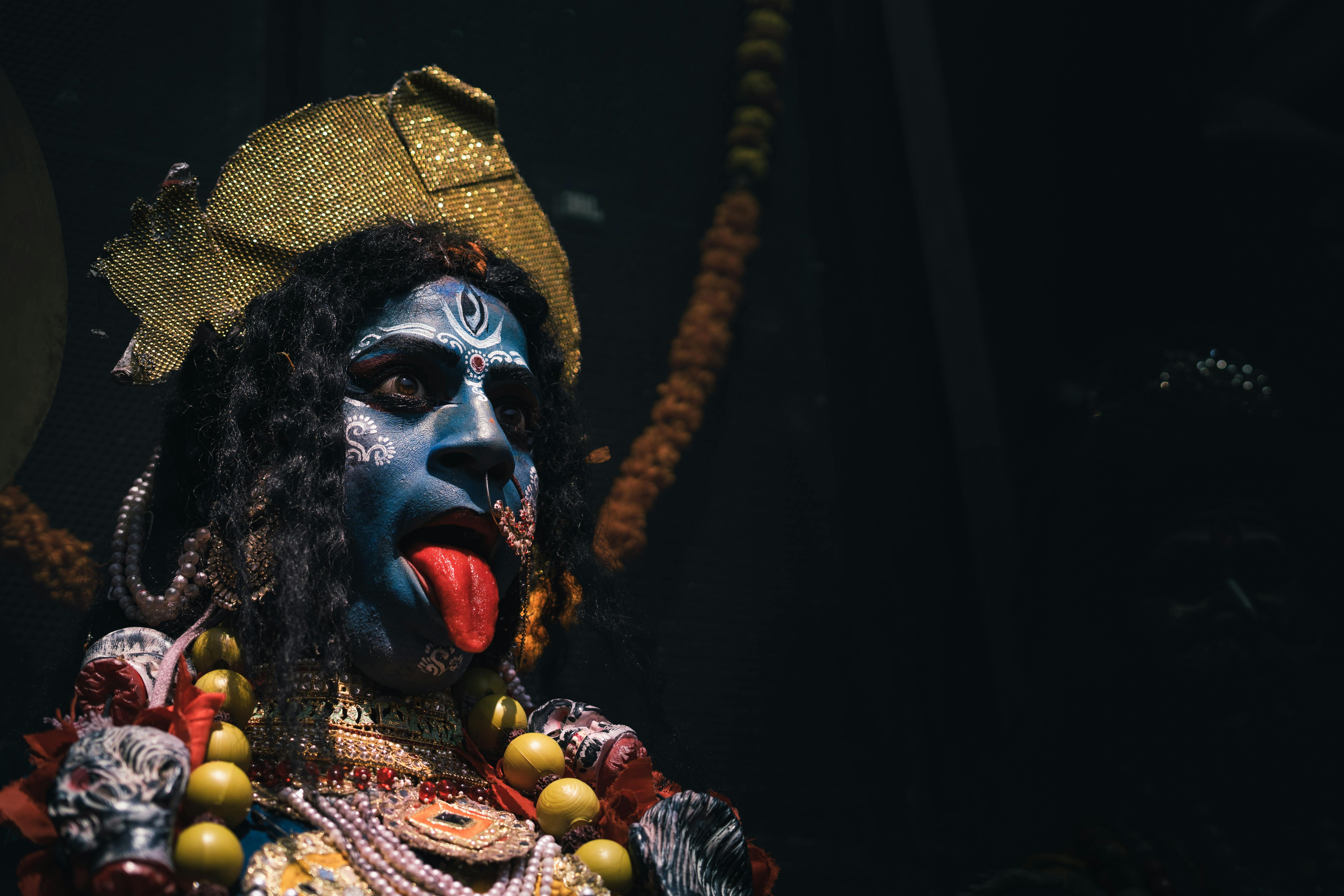 Free Vivid depiction of Hindu goddess Kali with ornate costume, jewelry, and expressive makeup. Stock Photo