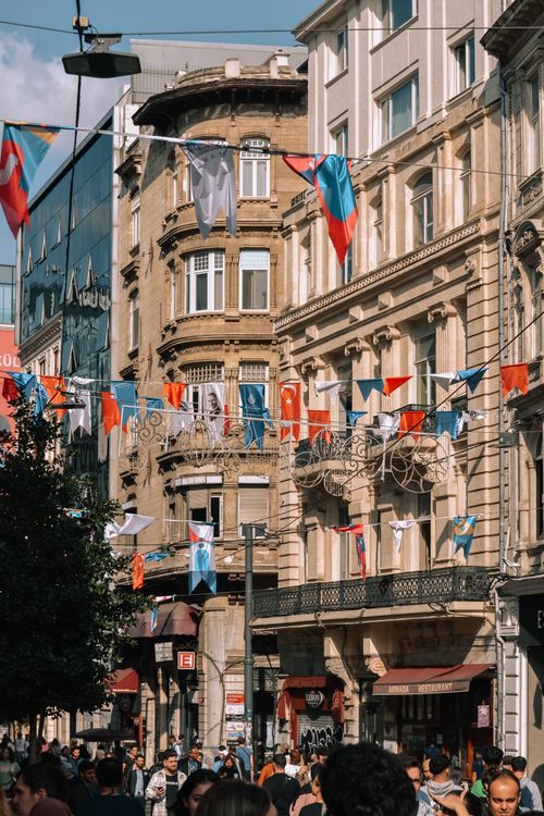 Free Bustling Istiklal Street in Istanbul adorned with colorful flags on a sunny day. Stock Photo