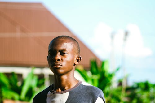 Photo of a Boy Standing Outside in Sunlight 