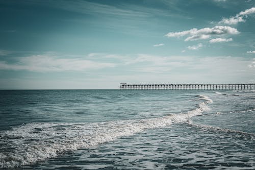 Wave on Sea Shore with Pier behind