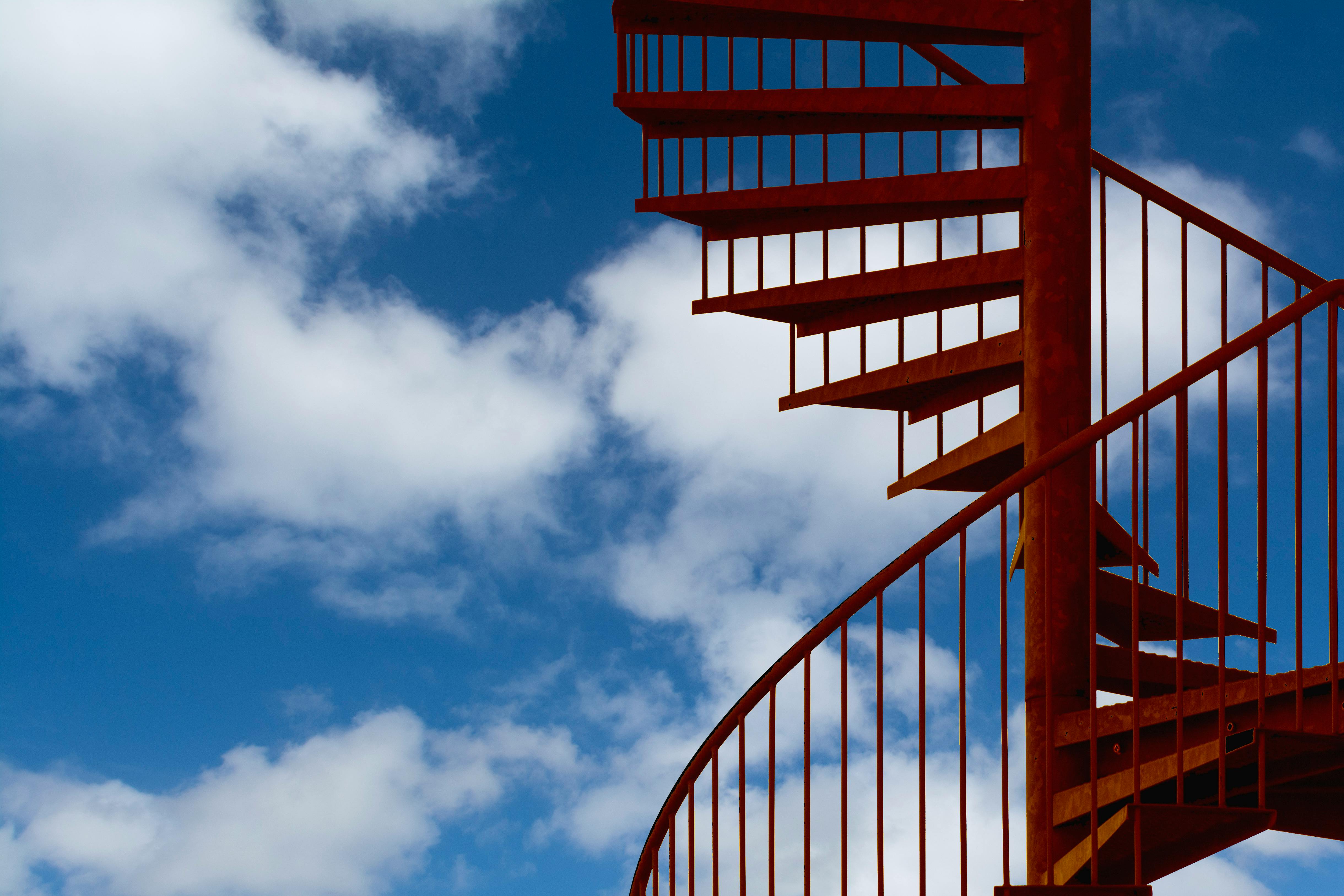 Escalera de caracol contra un cielo con nubes