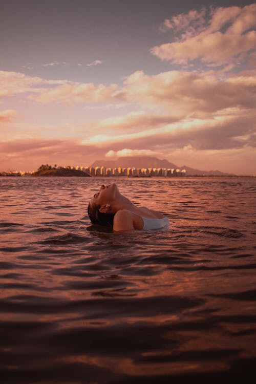 Woman Swimming in the Sea at Sunset