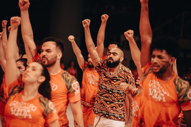 A Group Of People Standing With Their Fists Up 