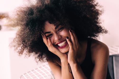 Free Photo of Smiling Woman with Hands on Her Chick Stock Photo