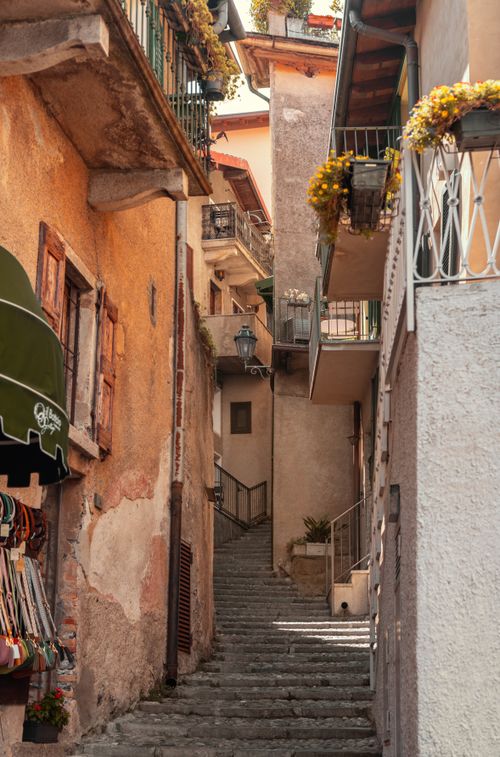 Free Explore a sunlit narrow alleyway with stone steps in a quaint historic town. Stock Photo