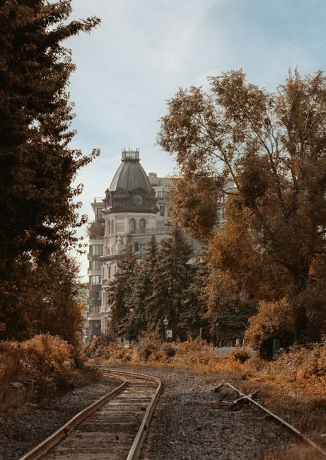Picturesque railway tracks in fall leading to an antique building