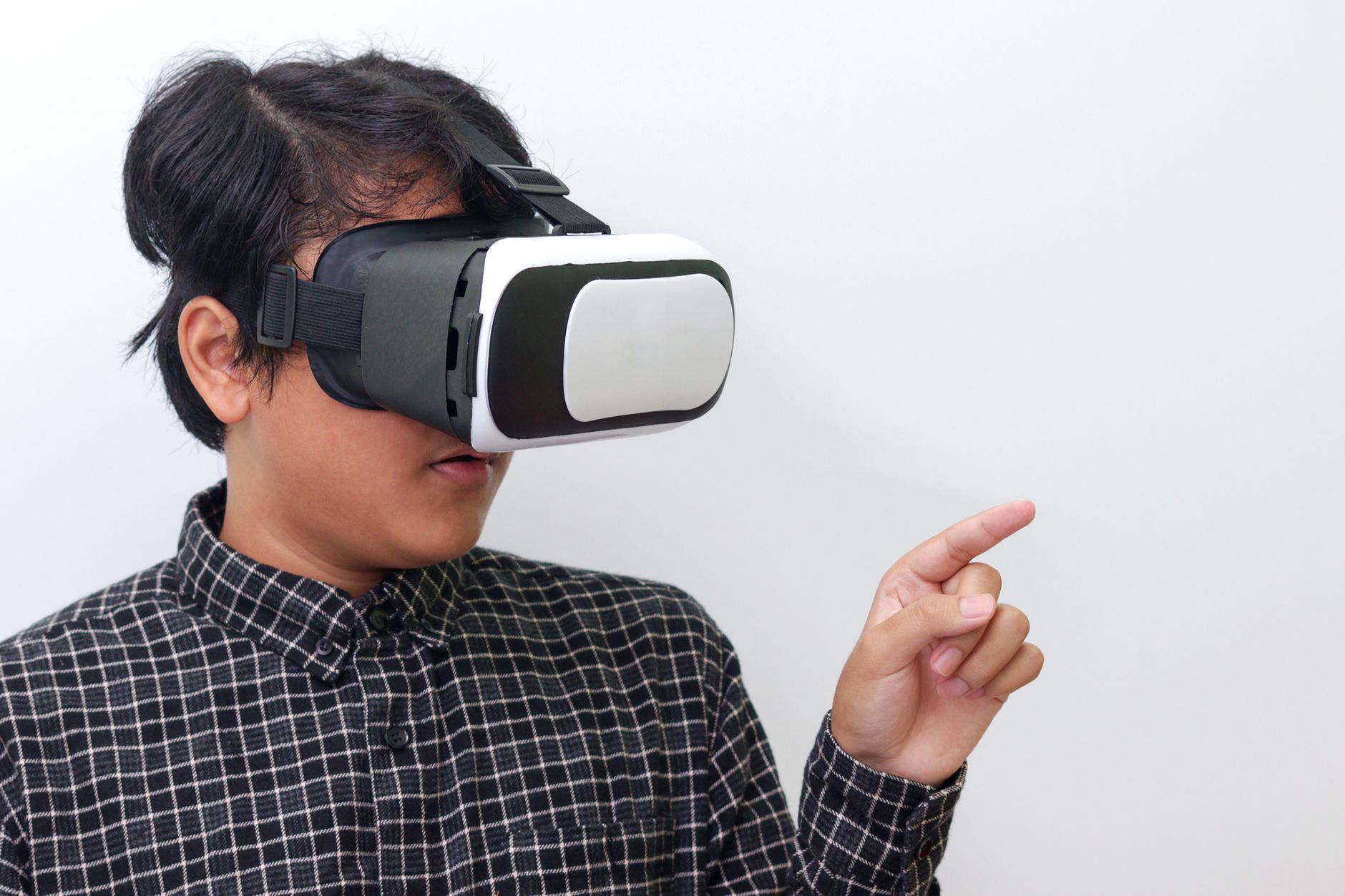 Adult wearing VR headset interacting with virtual environment indoors.