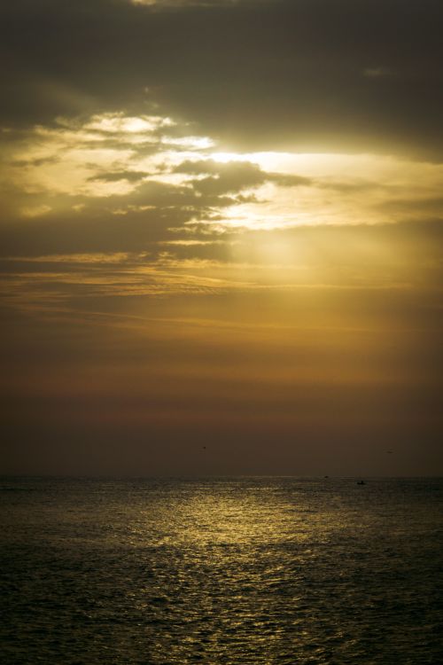 Free Dramatic sunset with sunbeams over the tranquil sea in Cinqueterre, Italy. Stock Photo