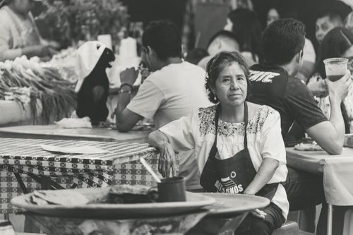 Free Elderly woman at a street market table in Puebla, Mexico in a black and white photo. Stock Photo