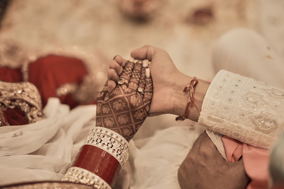 Hands of a traditional Indian wedding couple with henna