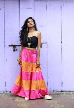 一位自信的女人穿着充满活力的服装，在户外的紫色墙壁前摆姿势