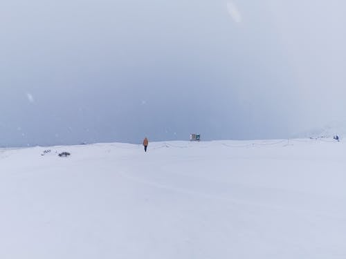 Man Walking in a Valley Covered with Snow