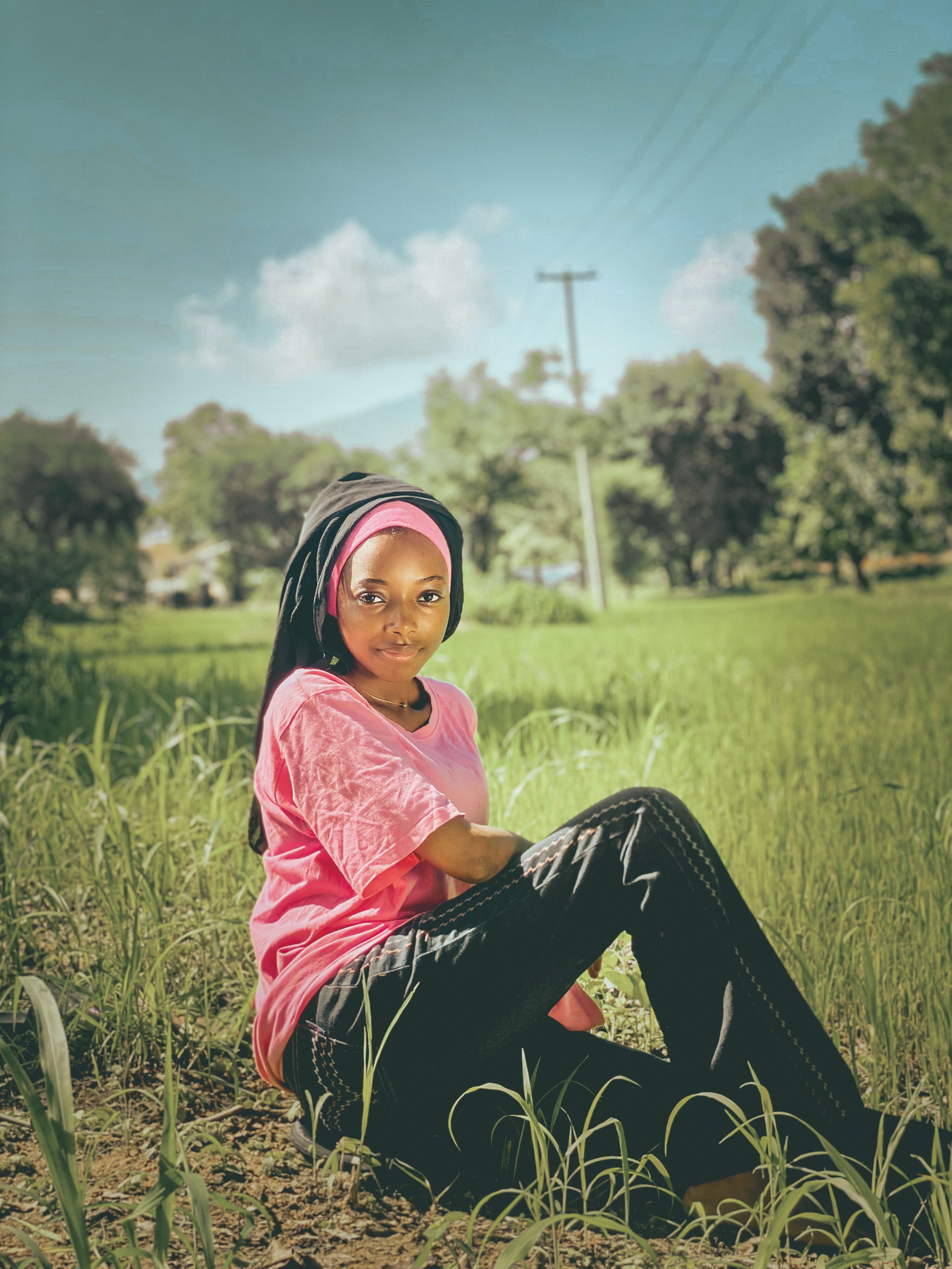 A Girl Sitting on a Grass Field · Free Stock Photo