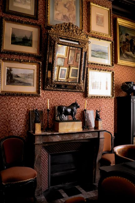 Sophisticated Parisian room with a fireplace, art, and elegant furniture.
