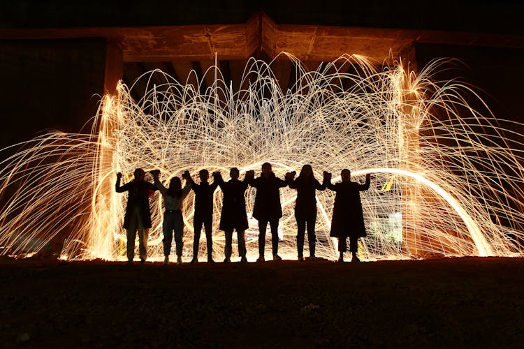 People Standing Together With Sparkling Lights Behind