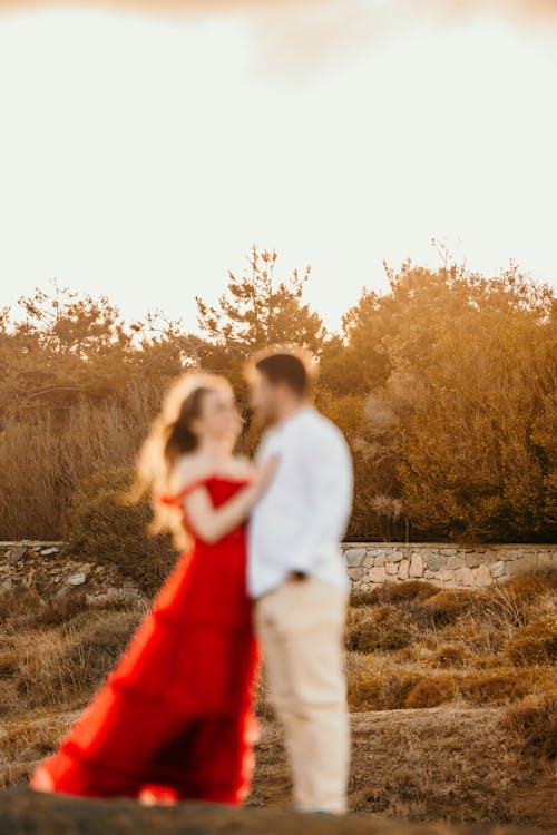 Couple on Grassland with Trees behind at Sunset