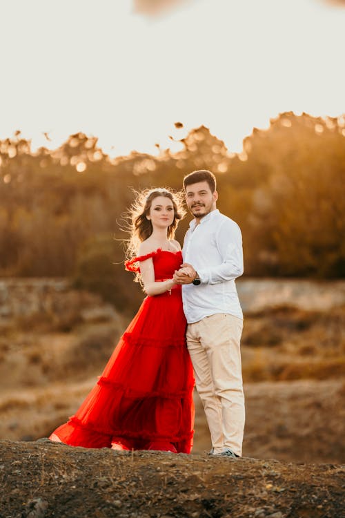 Elegant Couple Standing on a Field at Sunset