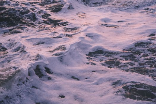 Tranquil ocean waves with delicate foam during a picturesque sunset, evoking a sense of calm.