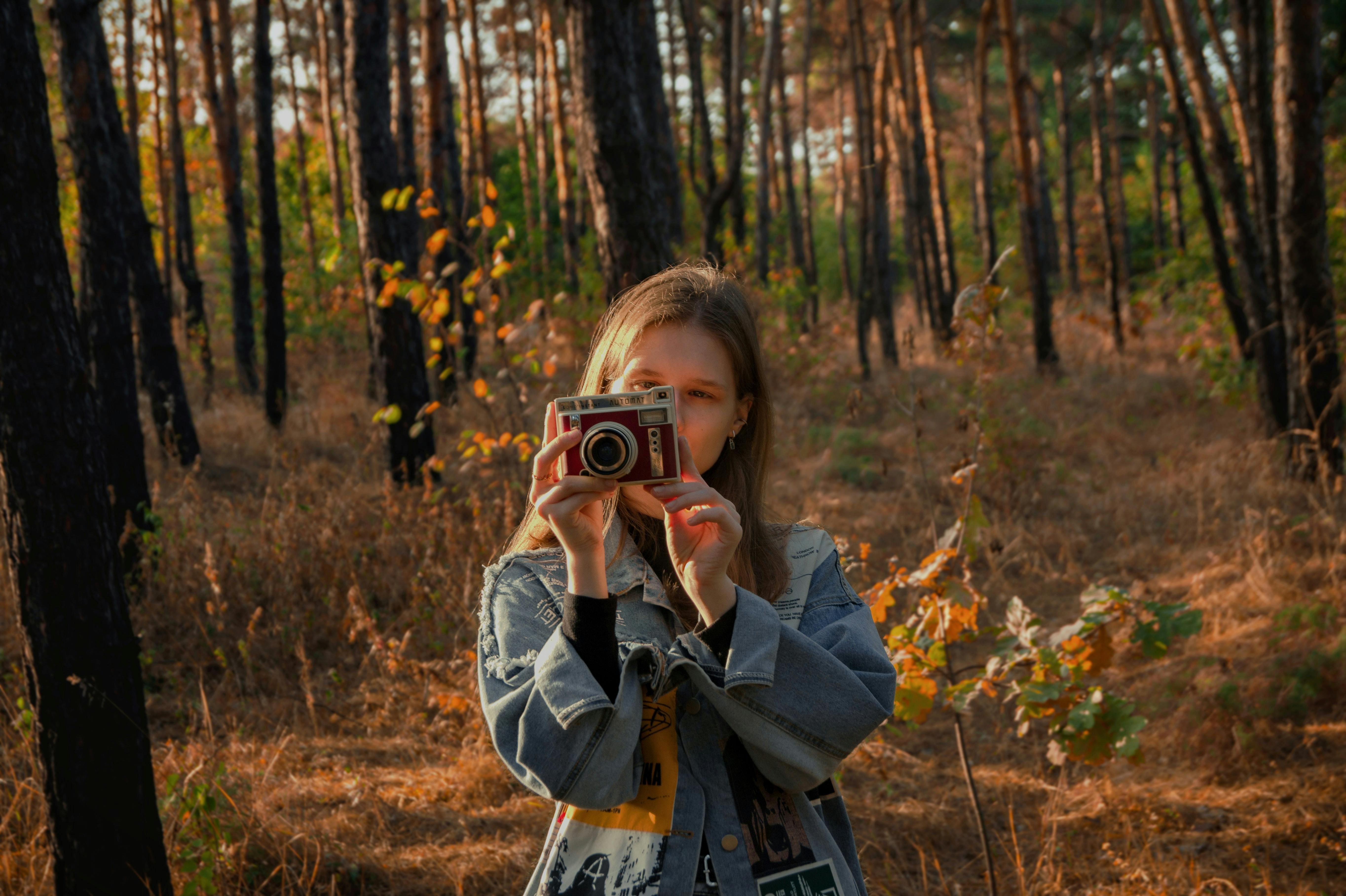 Woman Taking Pictures with Camera in Forest