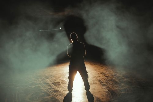 Free A dramatic silhouette of a man standing in smoke with backlighting, creating a mysterious atmosphere. Stock Photo
